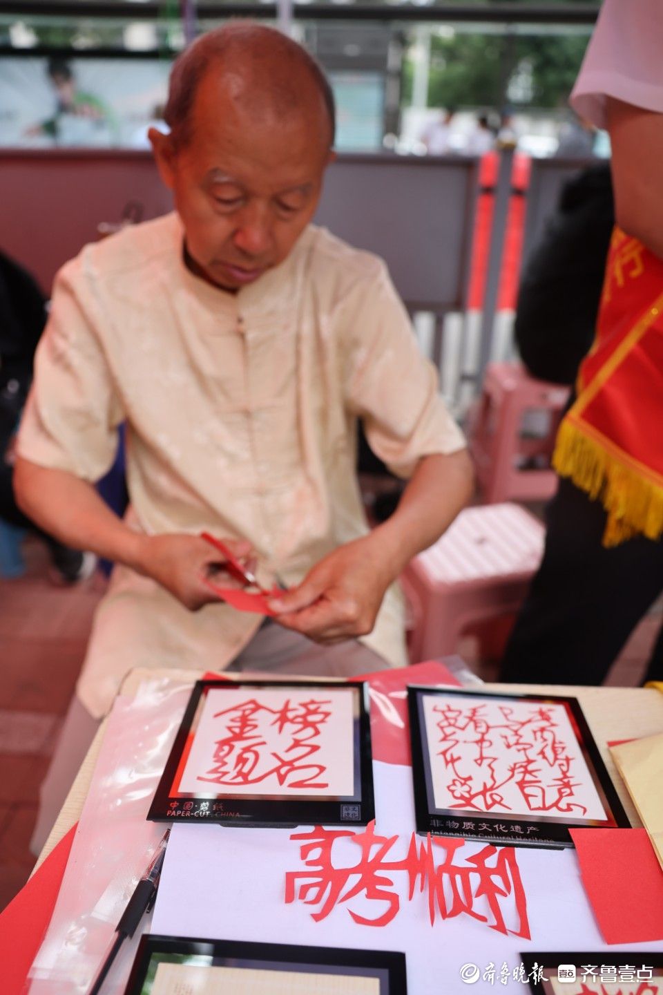 高考考场外，剪纸艺人送上别样礼物祝福考生