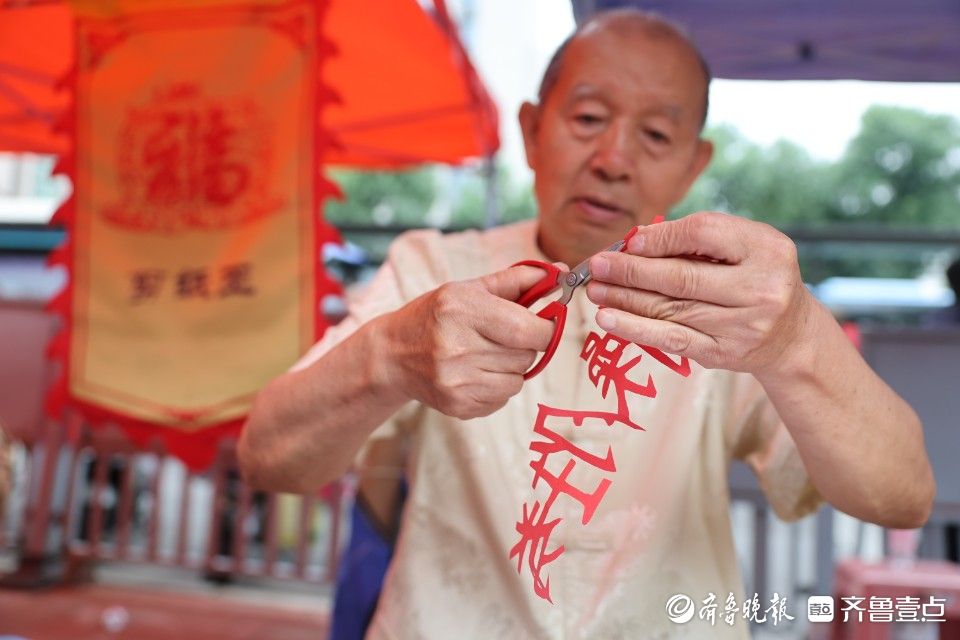 高考考场外，剪纸艺人送上别样礼物祝福考生