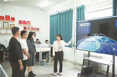 在“天算星座”华东地面站内，烟台大学群智感知实验室成员正在分析数据。受访者供图