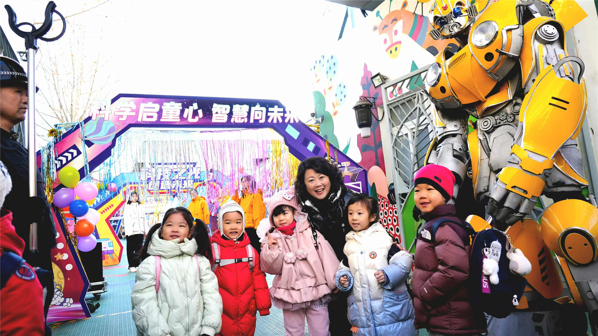 北京市東城區(qū)欣苑幼兒園的小朋友們在老師與機器人共同迎接下入園。幼兒園供圖