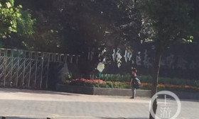 【组图】小学生上学迟到 听到国歌后校门外立正敬礼